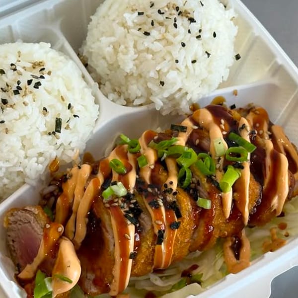 Wailua Drive In's Hawaiian plate lunch with crispy ahi, rice, and sauces in a takeout container.
